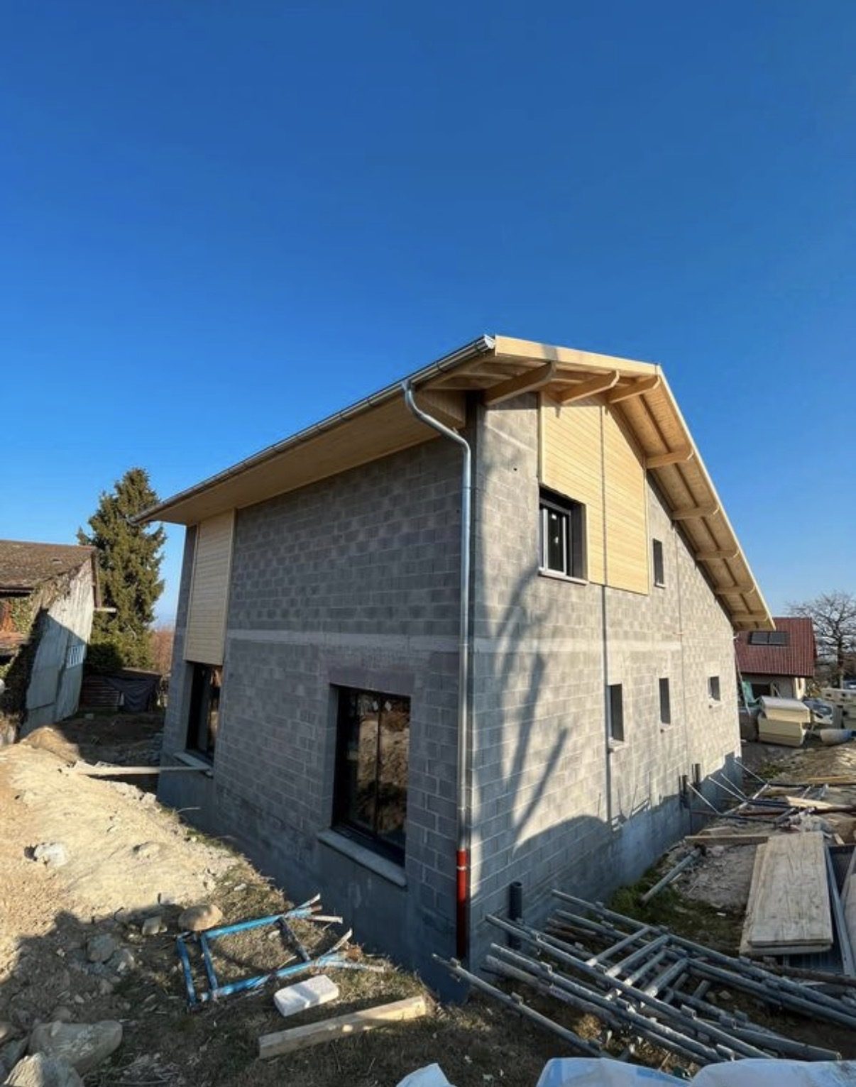 Façade en agglos avec bardage bois sur le pignon